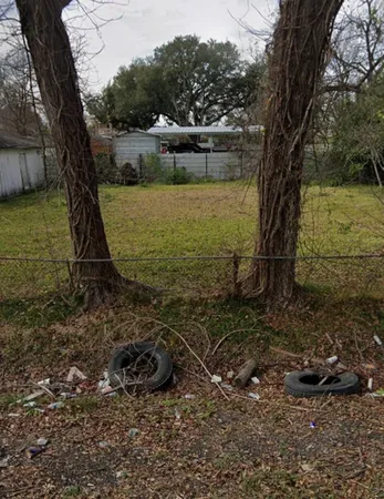a view of a lake with a yard and large trees