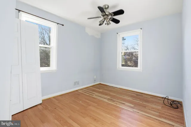 a view of a big room with wooden floor and windows