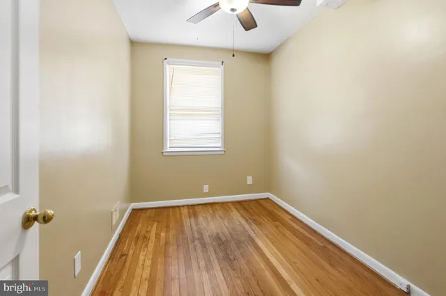 an empty room with a window and wooden floor