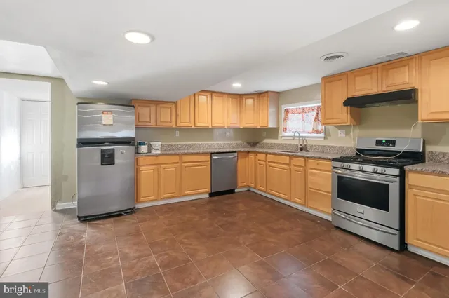 a kitchen with stainless steel appliances granite countertop a stove sink and cabinets