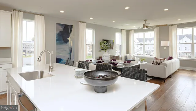 a large white kitchen with sink a large window and a counter space