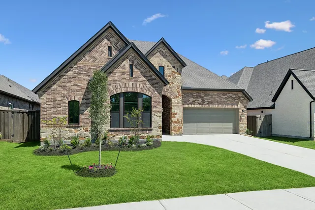 a front view of a house with a garden and yard