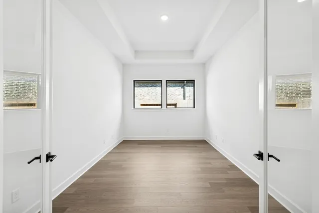 a large white kitchen with kitchen island a sink white cabinets and stainless steel appliances