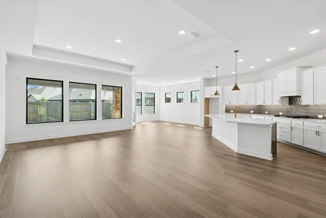 a kitchen with granite countertop a sink a stove and cabinets