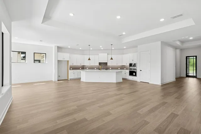 a view of kitchen with kitchen island white cabinets and stainless steel appliances