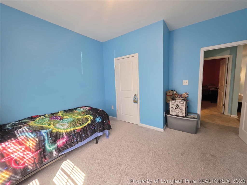 317 Laurel Lake Road Salemburg, NC 28385 - Photo 17 of 29 a bed sitting in a bedroom next to a window