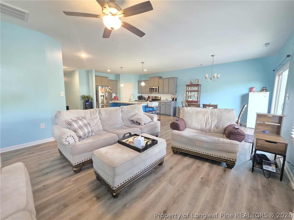 317 Laurel Lake Road Salemburg, NC 28385 - Photo 6 of 29 a living room with furniture and a chandelier