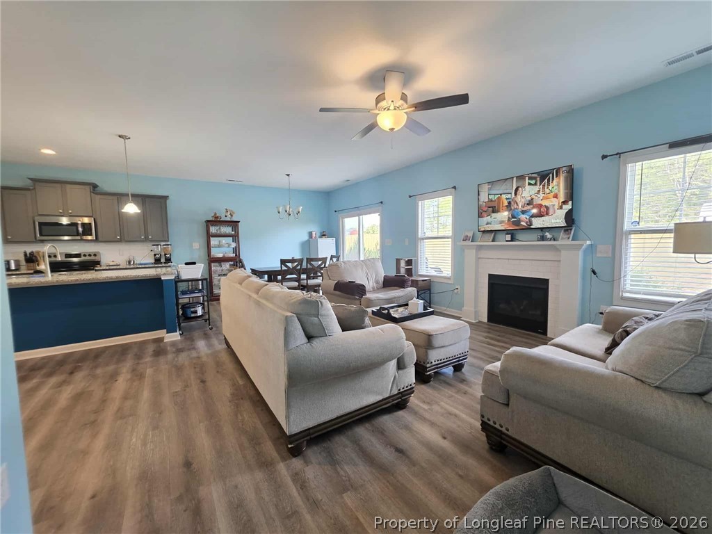 317 Laurel Lake Road Salemburg, NC 28385 - Photo 7 of 29 a living room with furniture a fireplace and a flat screen tv