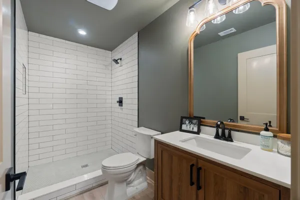 a bathroom with a sink a toilet and shower