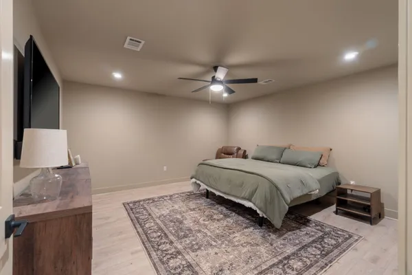a bedroom with a large bed and a chandelier