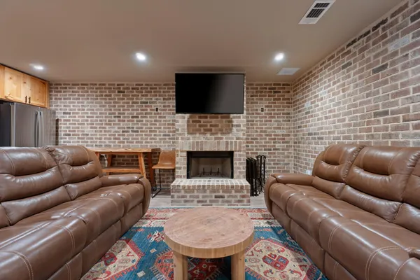 a living room with furniture a flat screen tv and a fireplace