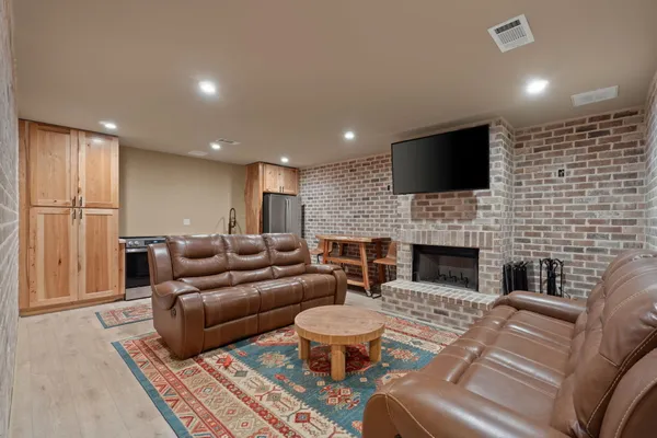 a living room with furniture a fireplace and a flat screen tv
