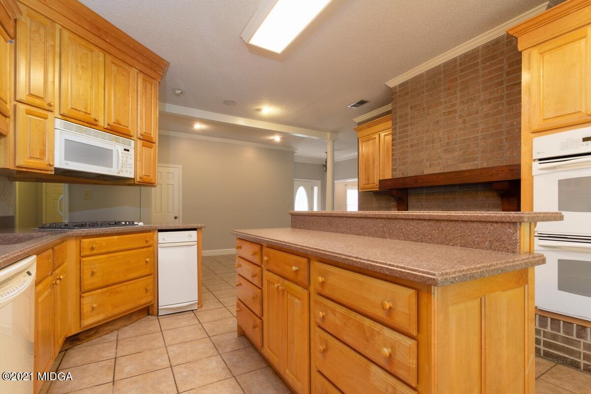 903 Tucker Road Macon, GA 31210 - Photo 11 of 31 a kitchen with stainless steel appliances granite countertop a sink and cabinets