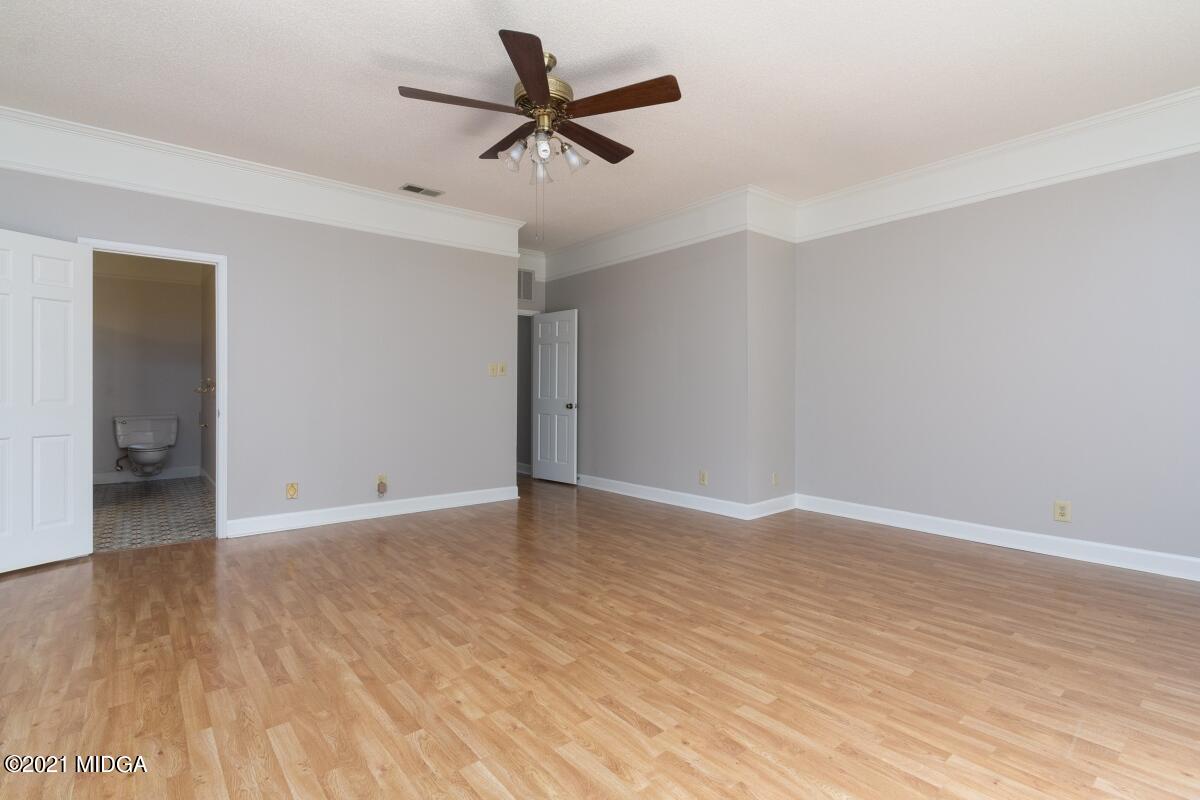 903 Tucker Road Macon, GA 31210 - Photo 16 of 31 an empty room with wooden floor and ceiling fan