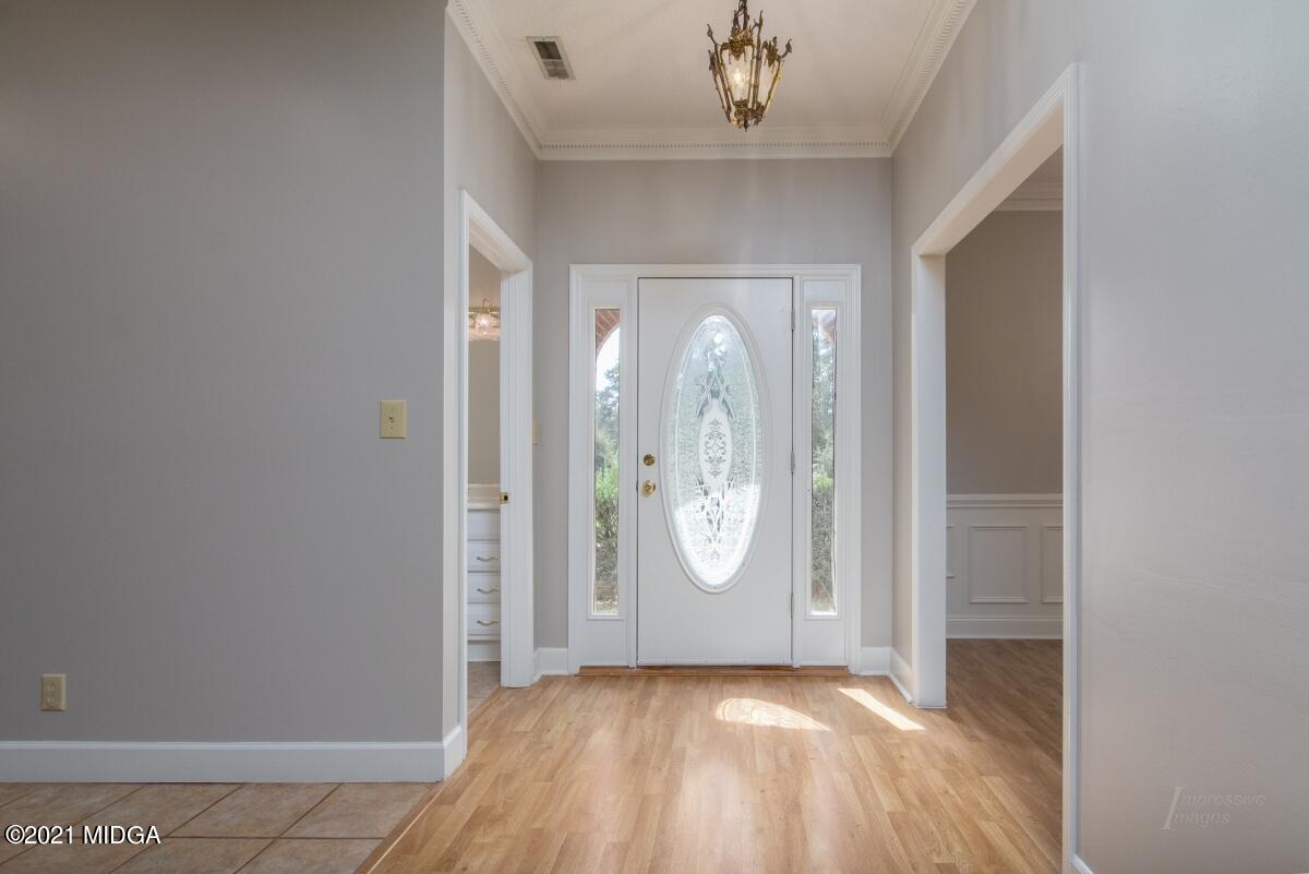 903 Tucker Road Macon, GA 31210 - Photo 4 of 31 an empty room with wooden floor and mirror