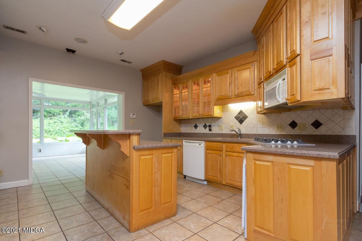 903 Tucker Road Macon, GA 31210 - Photo 9 of 31 a kitchen with granite countertop a sink a counter top space and cabinets
