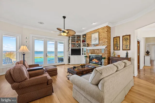 a view of a living room and balcony with wooden floor and furniture