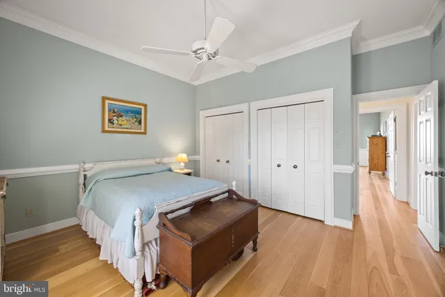 a spacious bedroom with a bed and a table with wooden floor