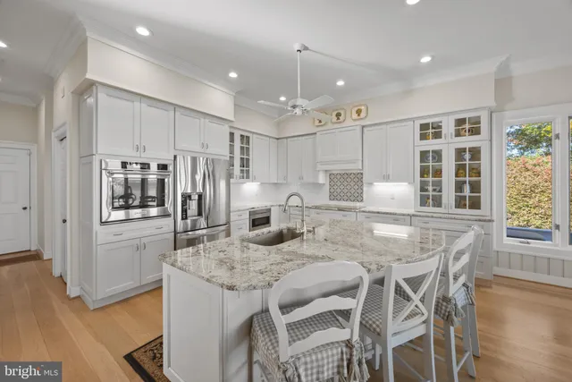 a kitchen with stainless steel appliances granite countertop a kitchen island a stove and a sink