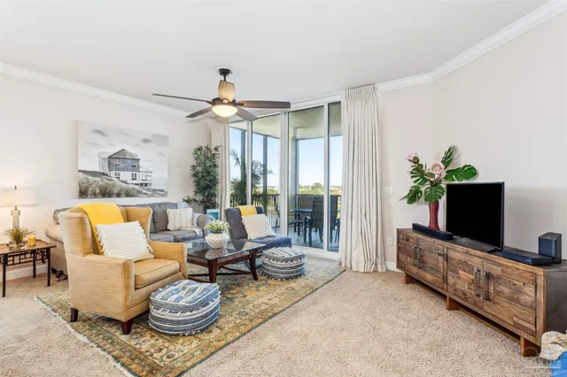 a living room with furniture a flat screen tv and a floor to ceiling window