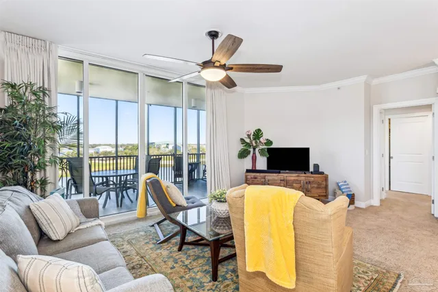 a living room with furniture a ceiling fan and a floor to ceiling window