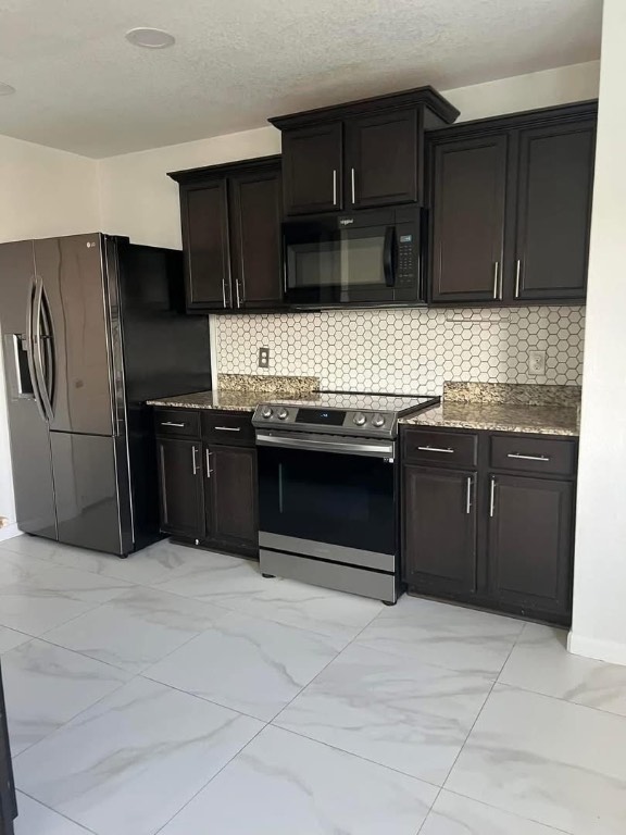 329 Yearwood Lane, Unit 11C Jarrell, TX 76537 - Photo 3 of 10 a kitchen with stainless steel appliances granite countertop a stove a sink and a refrigerator