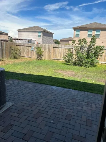 a view of a house with a yard and a large tree