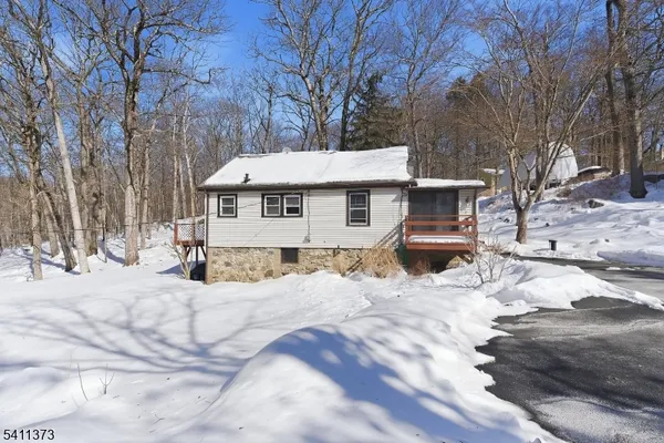 a view of a white house with a yard covered in snow