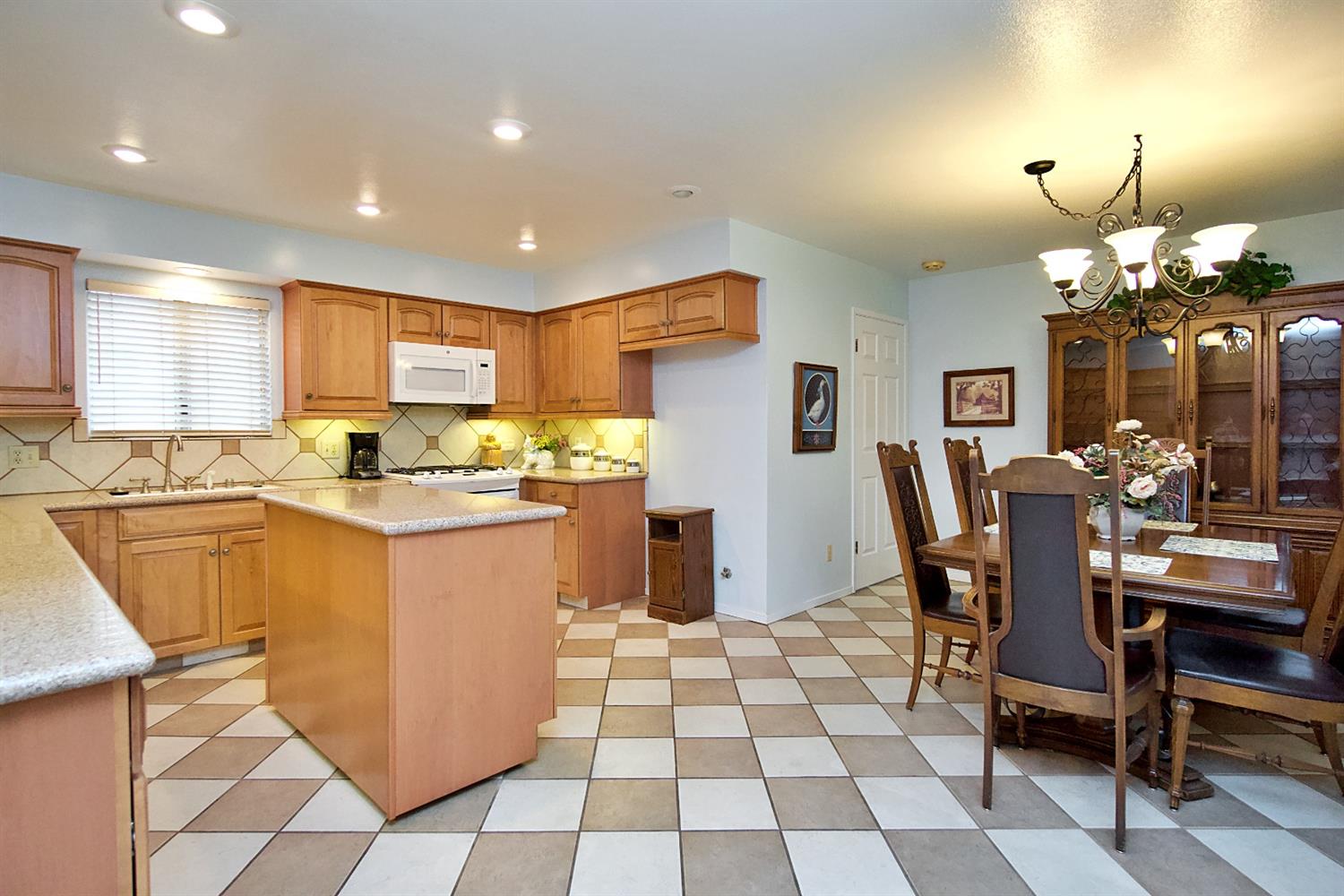 1004 Joy Street Madera, CA 93637 - Photo 13 of 29 a kitchen with a dining table chairs and refrigerator