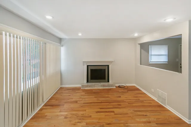 a view of an empty room with a window and fireplace