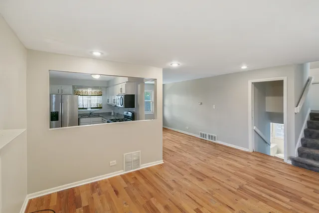 a view of a kitchen with wooden floor and a refrigerator