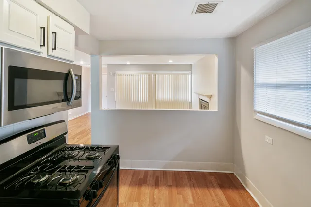 a kitchen with wooden floor and a stove top oven
