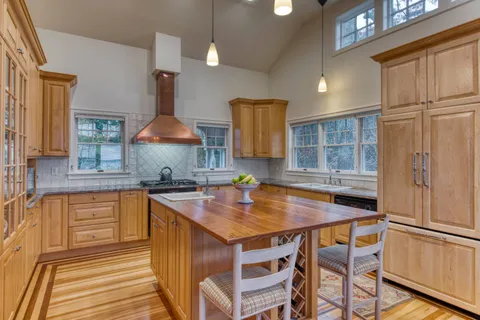 a kitchen with stainless steel appliances granite countertop a sink and a refrigerator