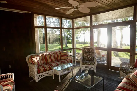 a living room with furniture and floor to ceiling windows