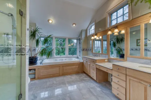 a large white kitchen with a large window and stainless steel appliances