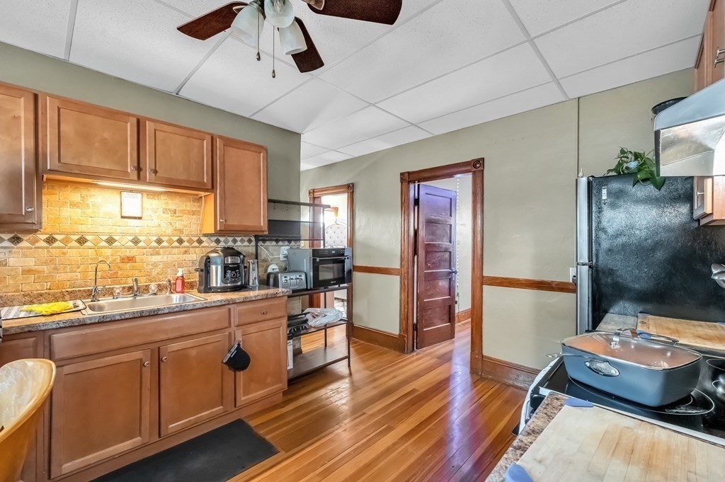 7-9 Kosciusko Street Springfield, MA 01151 - Photo 6 of 21 a kitchen with stainless steel appliances kitchen island granite countertop a refrigerator a stove and white cabinets with wooden floor