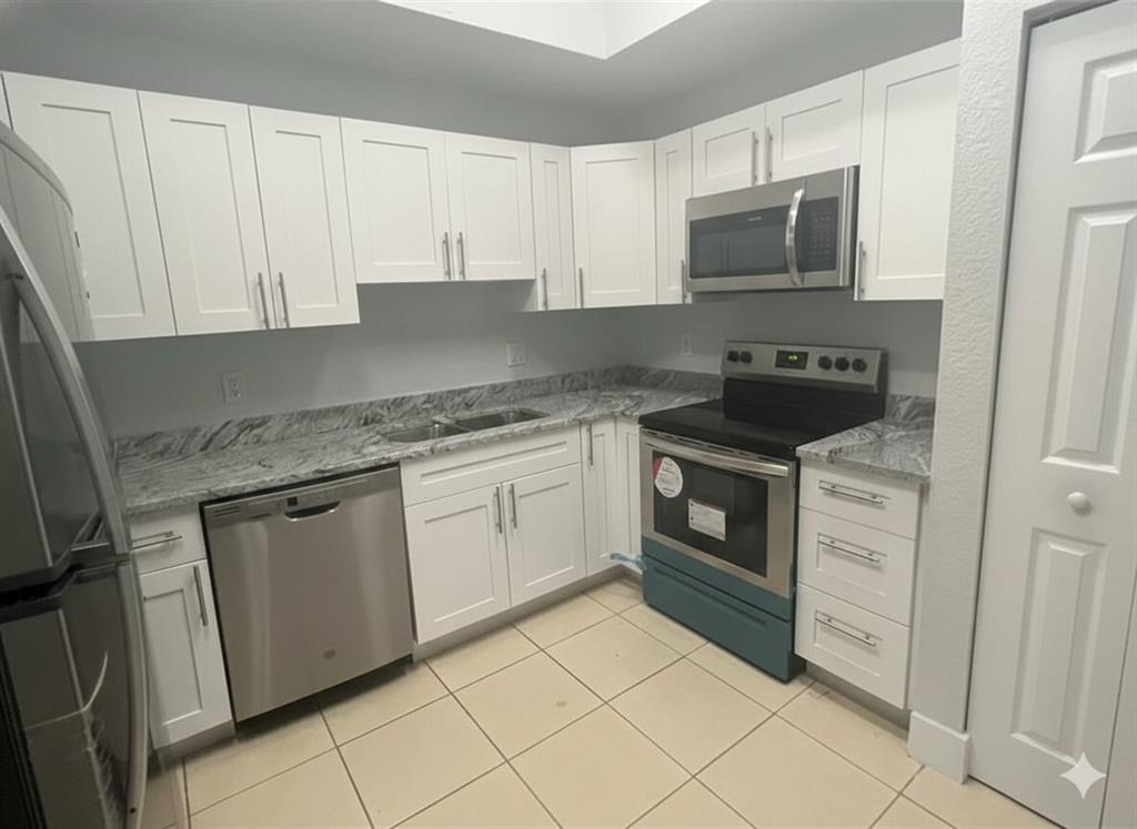 2801 Riverside Drive, Unit 204 Coral Springs, FL 33065 - Photo 3 of 18 a kitchen with granite countertop white cabinets stainless steel appliances and sink