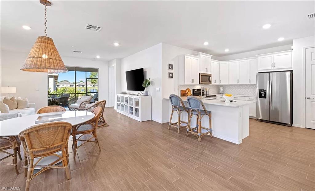 a living room with stainless steel appliances kitchen island granite countertop furniture and a flat screen tv