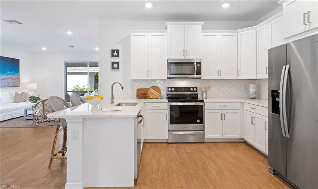 1213 Enbrook Loop Naples, FL 34114 - Photo 6 of 24 a kitchen with stainless steel appliances a stove sink and microwave