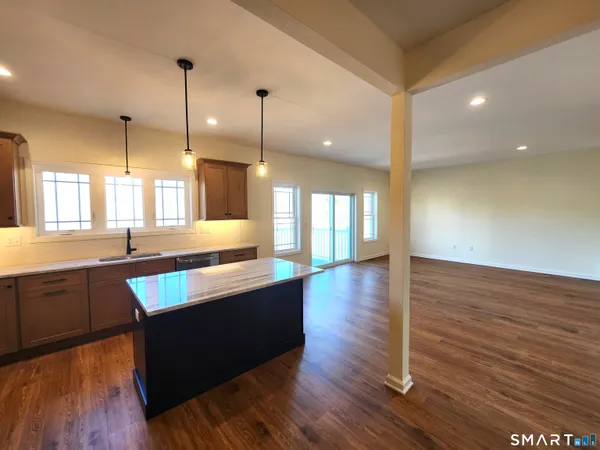 a large kitchen with wooden floors and living room