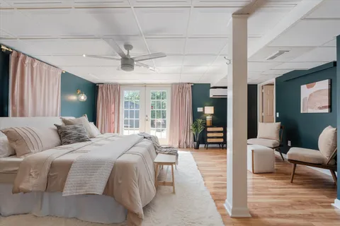 a spacious bedroom with a bed a couch and a chandelier