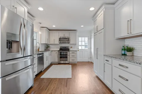 a kitchen with stainless steel appliances a refrigerator sink and microwave