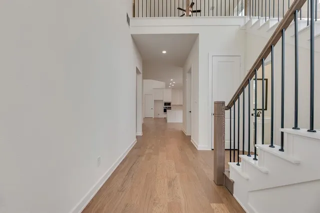 a view of a hallway with wooden floor and staircase