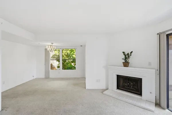 a view of an empty room with a fireplace and a window