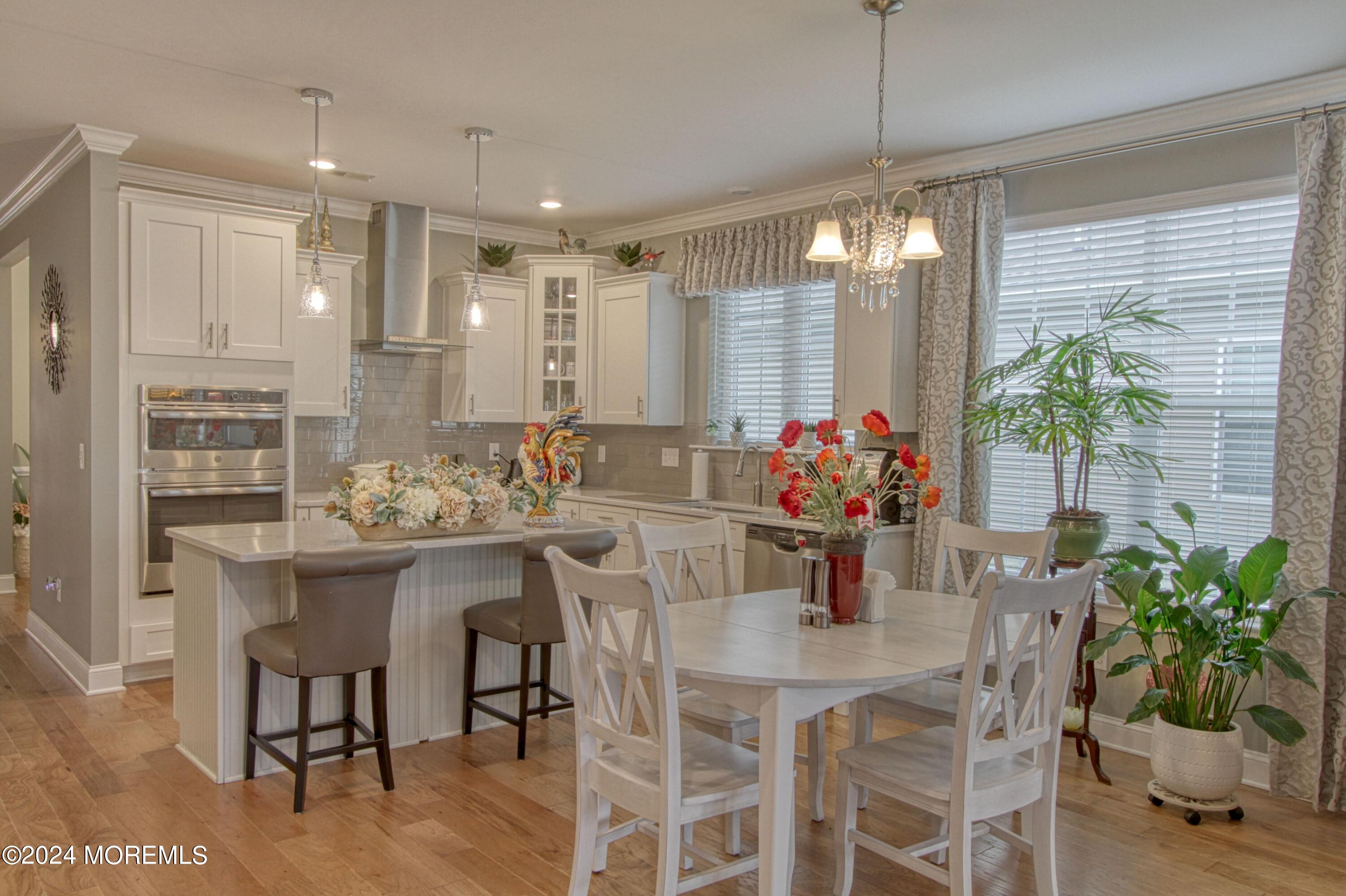 39 Butler Drive Barnegat, NJ 08005 - Photo 6 of 62 a kitchen with a dining table chairs and white cabinets