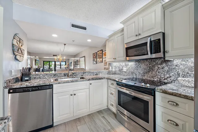 a kitchen with granite countertop cabinets stainless steel appliances and sink
