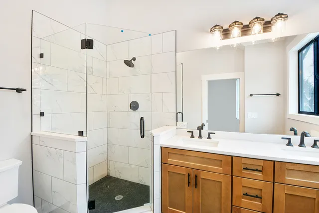 a bathroom with a sink shower and a mirror