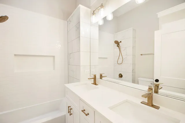 a bathroom with a sink vanity granite tub shower and a mirror