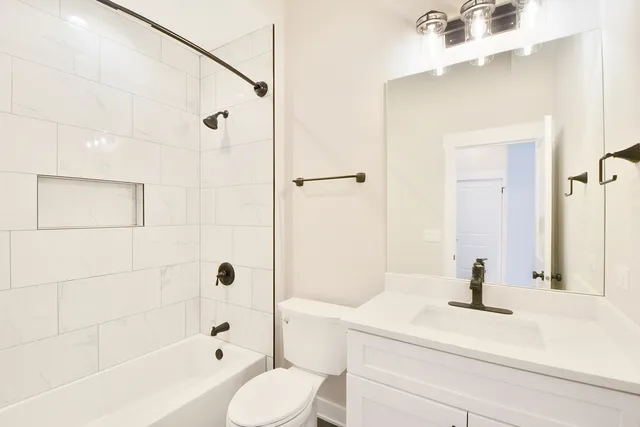 a bathroom with a sink a toilet a mirror and shower