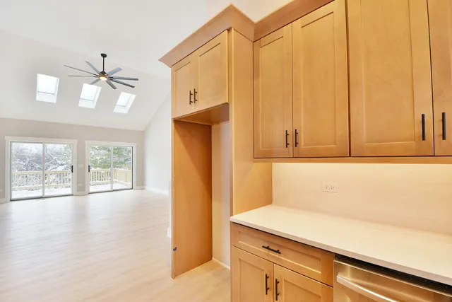 a kitchen with a white cabinets and wooden floor